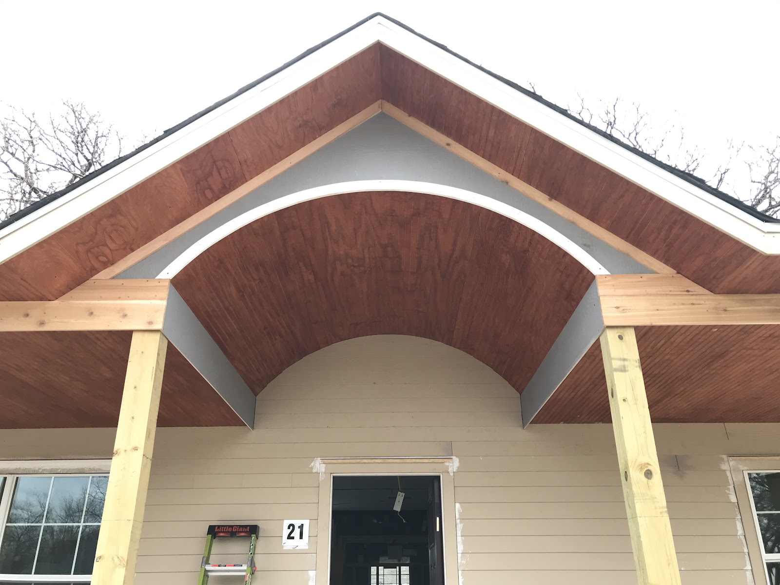 Arched stained-wood porch ceiling built and trimmed by LKP Woodworks