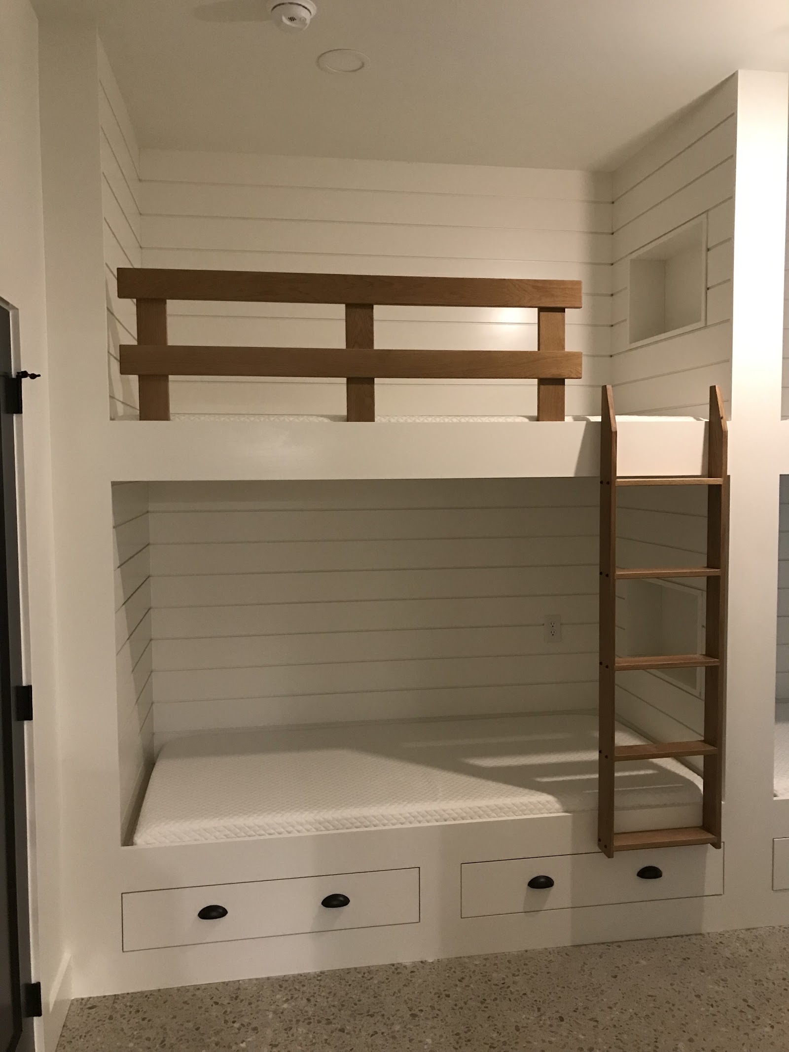Built-in bunk beds with shiplap, storage drawers, and a white oak ladder by LKP Woodworks