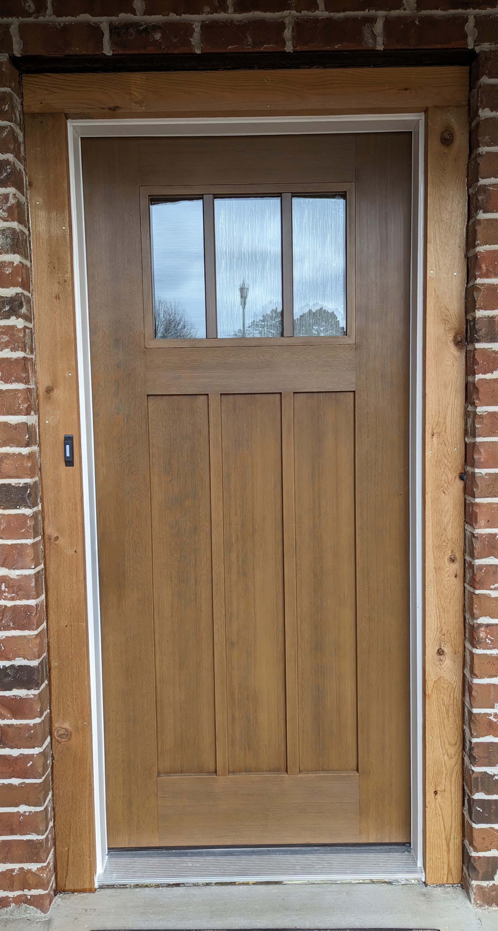Craftsman front door with stained oak casing installed by LKP Woodworks