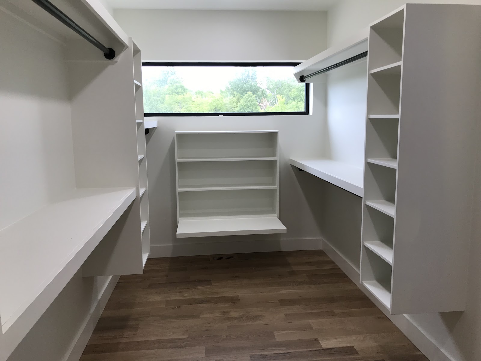 Custom walk-in closet with built-in shelving, shoe rack, and hanging rods built by LKP Woodworks