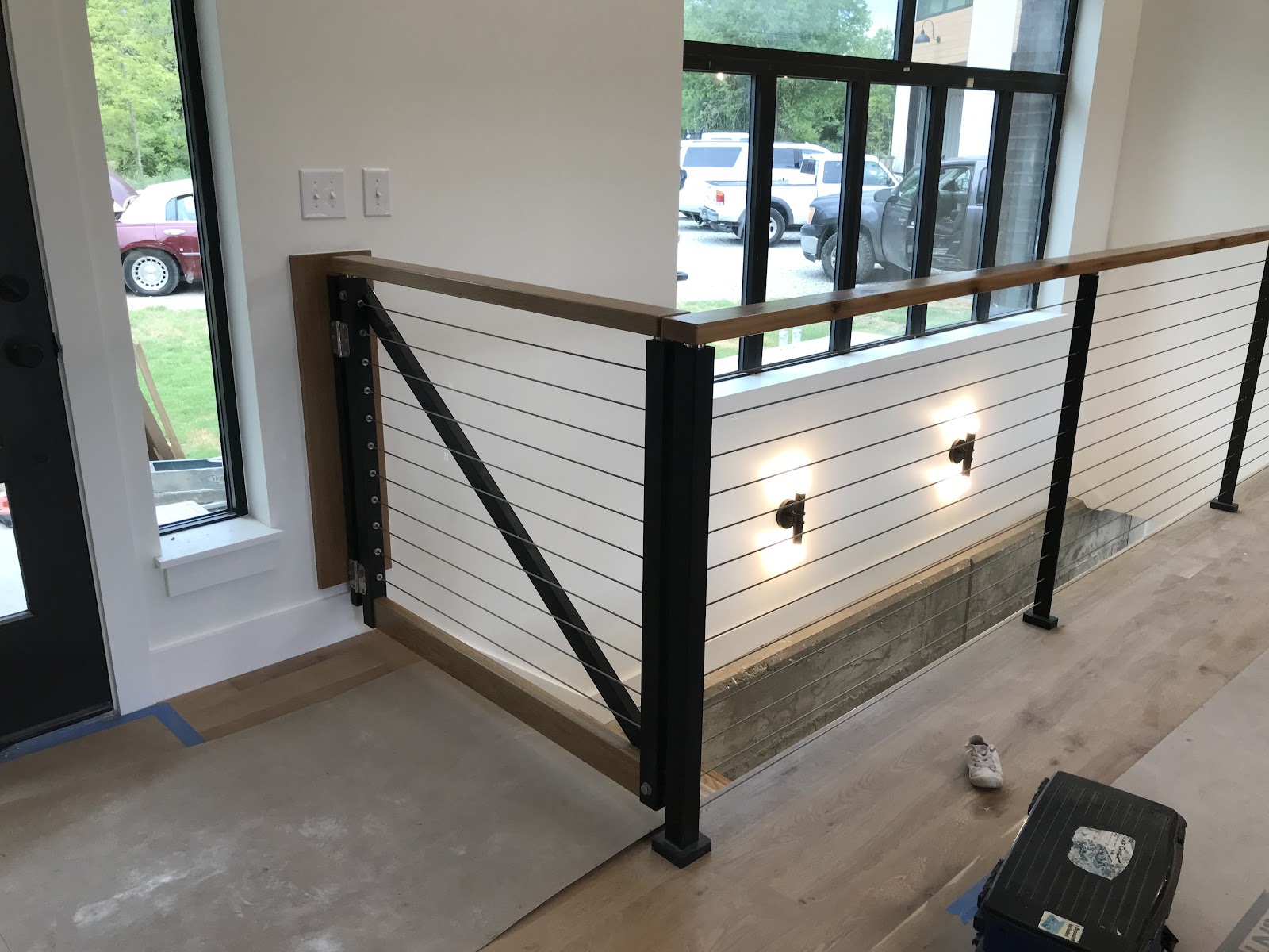 Interior stair landing with wood-capped cable railing built by LKP Woodworks