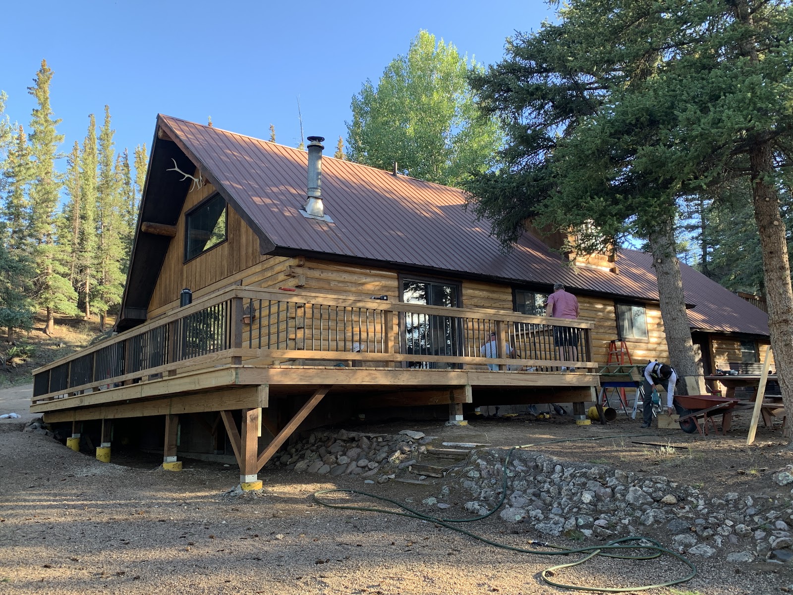 New wraparound deck with black balusters built by LKP Woodworks on a log home