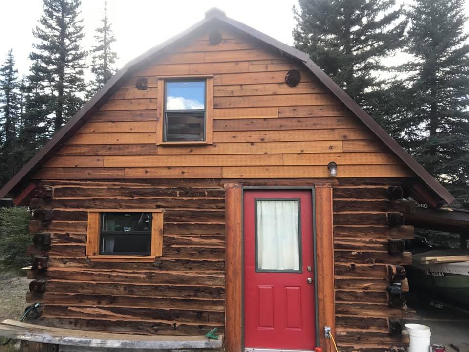 Log cabin restored by LKP Woodworks with new siding and windows