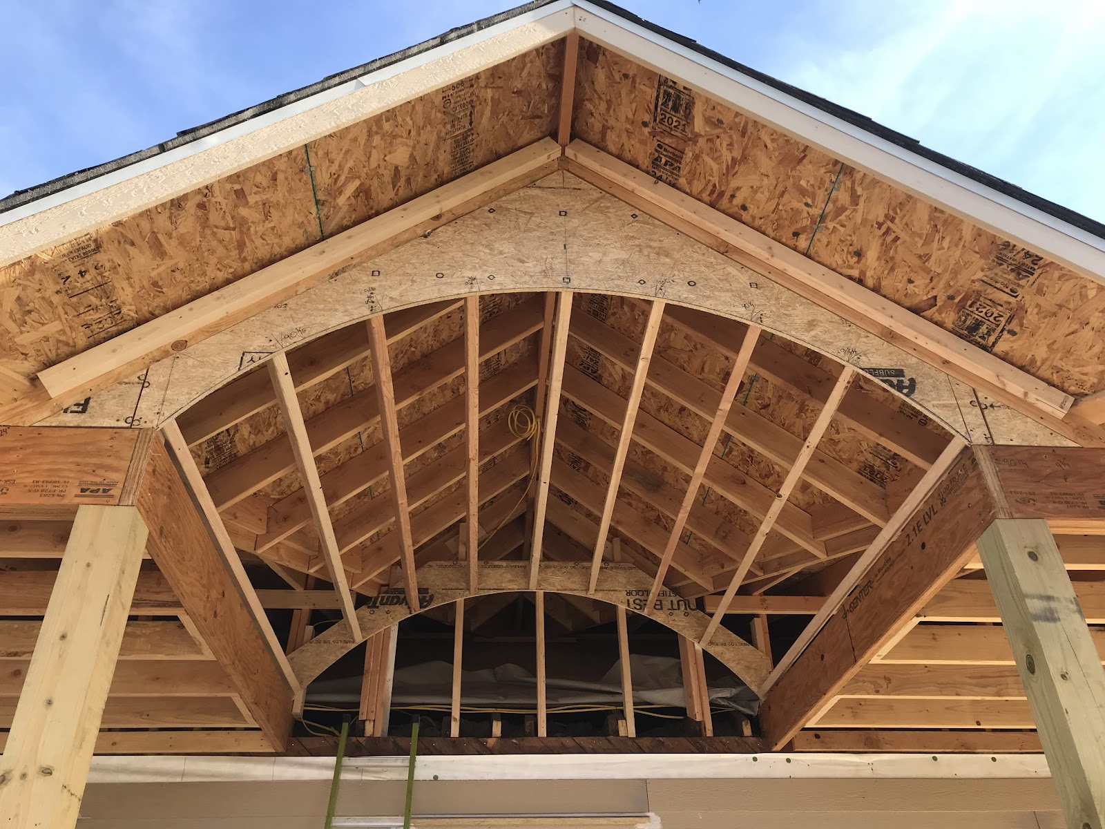Arched porch gable framing by LKP Woodworks with rafters and structural sheathing